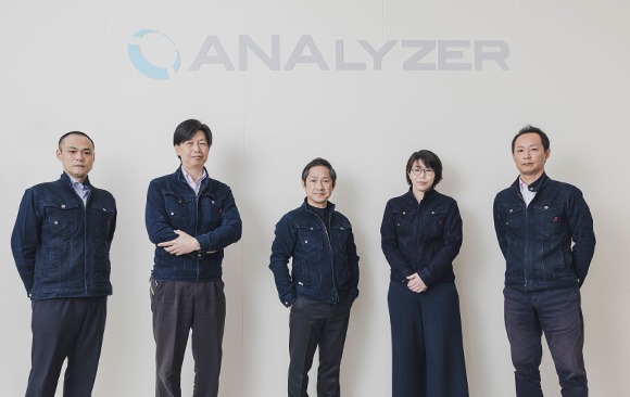 自信がある表情で立つANALYZER株式会社の社員